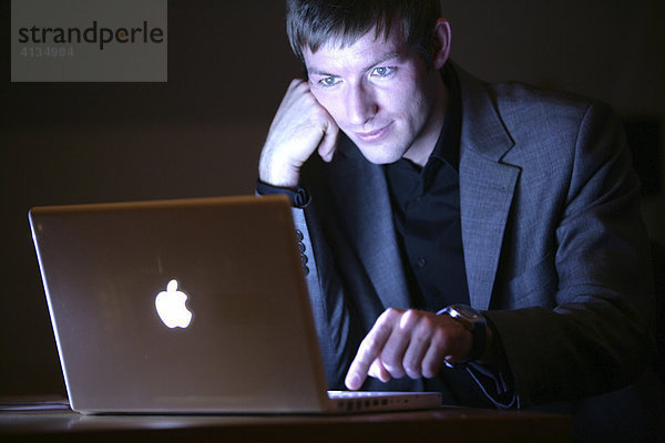 DEU  Bundesrepublik Deutschland : Junger Mann arbeitet an einen Laptop Computer  Apple