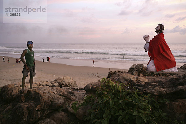 IND  Indien  Kerala  Trivandrum : Malabar Kueste  suedlich von Trivandrum. Jugendliche aus einem Fischerdorf. Jesus Figur am Strand nahe einer Wallfahrtskapelle.