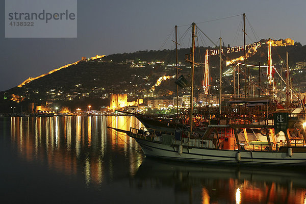 TUR  Türkei  Alanya : Tuerkische Riviera. Hafen mit Ausflugs Segelboote  Gullets  am Abend. Festung von Alanya  Zitadelle. Turm Kizil Kule .