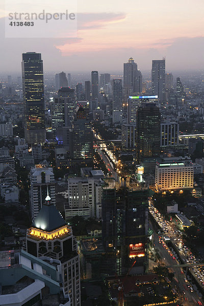 THA Thailand Bangkok Abendliche Skyline im Stadtteil Sathorn und Bangrak Blick zum Chao Phraya Fluss