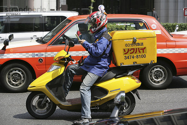 JPN  Japan  Tokio: Straßenszene  Motorrad  Rollerfahrer. Kurierfahrer