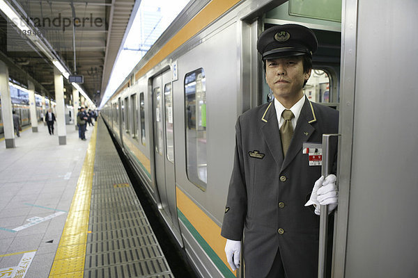 Schaffner  Nahverkehrzug am JR-Line Bahnsteig  Tokyo Station  Tokio  Japan  Asien