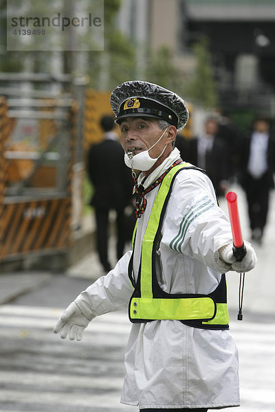 Wachmann regelt den Verkehr an der Ein- und Ausfahrt zu einem Gebäude  Tokio  Japan  Asien
