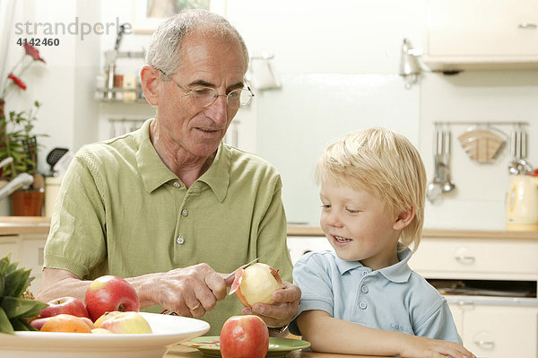 Opa schält Apfel für Enkel