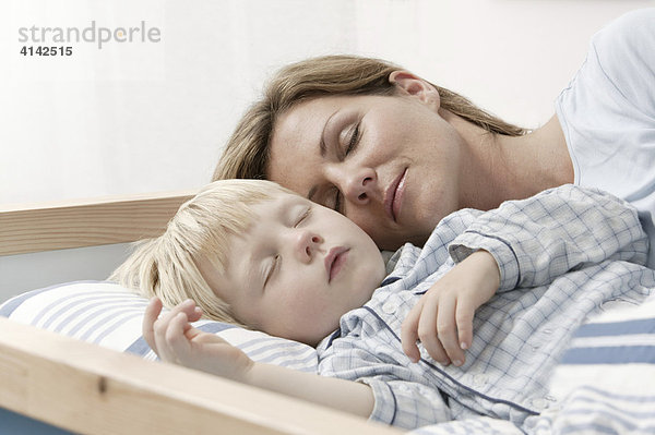 Mutter und Sohn schlafen im Bett