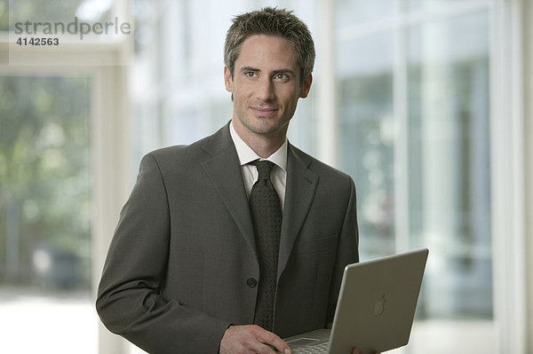 Mann im Anzug mit Laptop