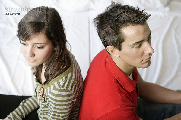 Junger Mann und junge Frau schweigen sich an  Rücken an Rücken