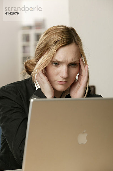 Blonde Frau mit Laptop  gestresst