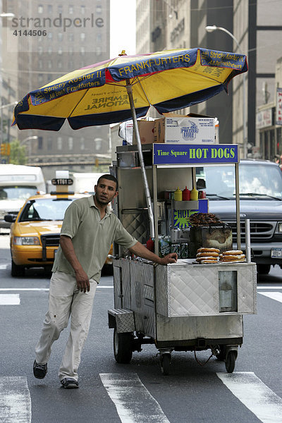 USA  Vereinigte Staaten von Amerika  New York City: Hot Dog Verkaeufer auf dem Weg zur Arbeit.