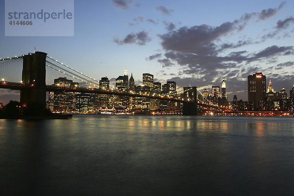 USA  Vereinigte Staaten von Amerika  New York City: Skyline von Sued-Manhattan  Financial District  in der Daemmerung  von Brooklyn aus gesehen. Brooklyn Bridge  East River.