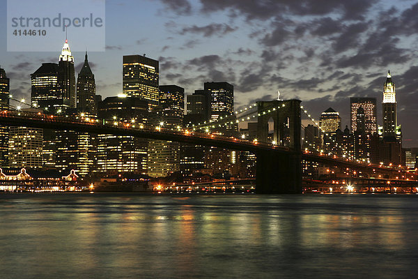 USA  Vereinigte Staaten von Amerika  New York City: Skyline von Sued-Manhattan  Financial District  in der Daemmerung  von Brooklyn aus gesehen. Brooklyn Bridge  East River.