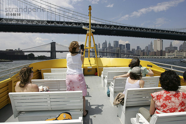 USA  Vereinigte Staaten von Amerika  New York City: NY Watertaxi bei der Fahrt auf dem East River. Skyline von Sued Manhattan. Manhattan und dahinter die Brooklyn Bridge.