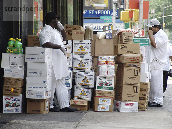 USA  Vereinigte Staaten von Amerika  New York City: Harlem 125th Street  Mitarbeiter eines Lebensmittel Geschaeftes raeumen eine neue Lieferung ein. machen Pause.