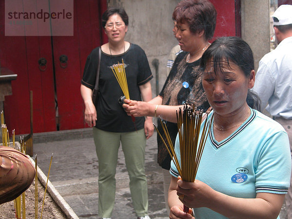 MAC  Macau: Buddhisten in einem Tempel der Altstadt. Der Rauch der Raeucherstaebchen soll die Aufmerksamkeit der Goetter auf die Betenden lenken.
