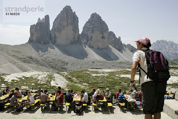 Touristen machen eine Pause auf der Terrasse von der Dreizinnenhütte  Drei Zinnen Gipfel  Dolomiten  Pustertal  Südtirol  Italien  Europa