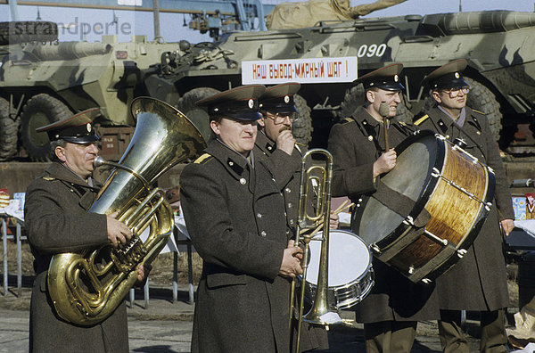 Russische Militärkapelle spielt Musik vor einem Eisenbahntransport mit gepanzerten Fahrzeugen beim Truppenabzug  Stendal  DDR  Europa