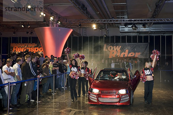 Cheerleader begleiten ein getuntes Fahrzeug in die Showhalle  Essen Motor Show  NRW  Germany