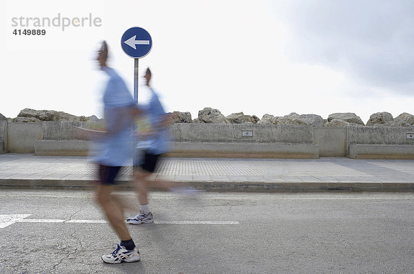 Marathonläufer passieren ein Verkehrsschild