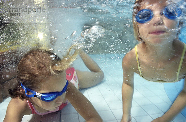 Zwei Kinder unter Wasser im Schwimmbad