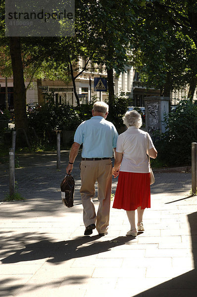 Seniorenpaar geht Hand in Hand