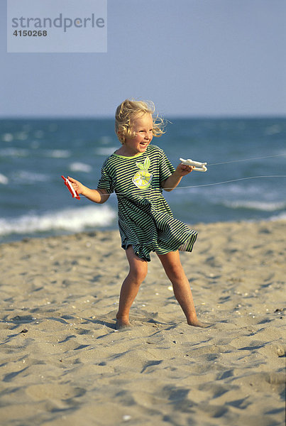 Fünfjährige am Strand mit Drachenschnüren