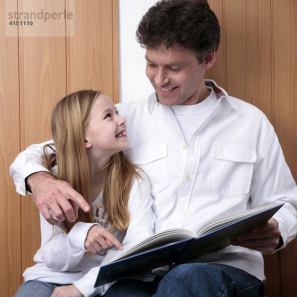 Vater und Tochter lesen in einem Buch