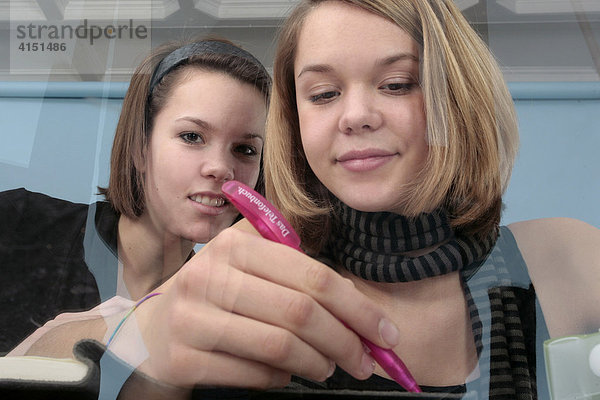 Zwei junge Mädchen machen gemeinsam Hausaufgaben