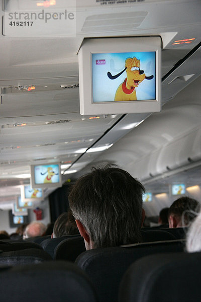 In einem Passagierflugzeug wird auf einem Unterhaltungsmonitor ein Disneyfilm gezeigt