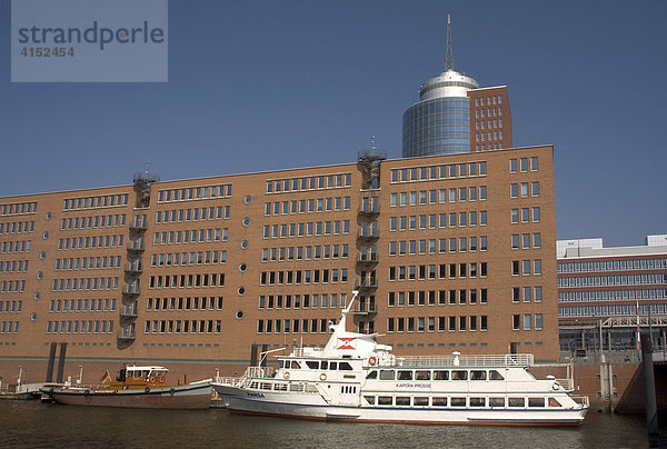 Ein Ausflugsschiff liegt vor dem Hanseatic Trade Center HTC an der Kehrwiederspitze in der Hamburger Hafencity