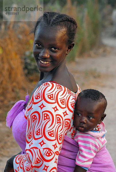 Junge Mutter mit ihrem Kind auf dem Rücken  Tanji  Gambia  Afrika