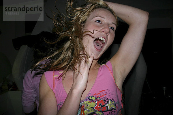 Junge Frau beim wilden Tanzen auf einer Party