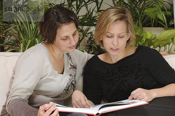 Zwei Frauen lesen ein Buch