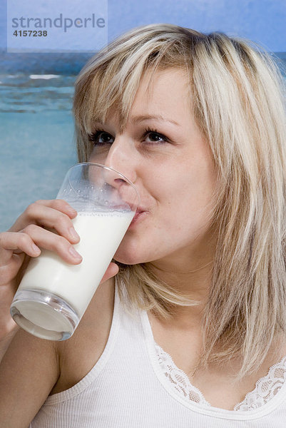 Blonde Frau in Unterwäsche trinkt ein Glas Milch  Fototapete
