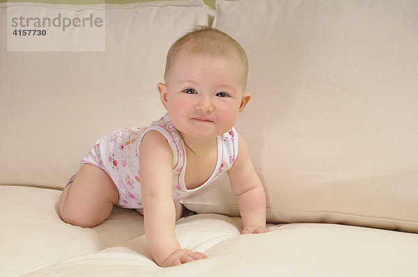 Baby in Unterhemd  Body  7 Monate  auf Sofa  krabbelt  Vierfüßlerstand