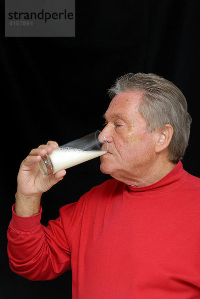 Senior trinkt Milch aus einem Glas