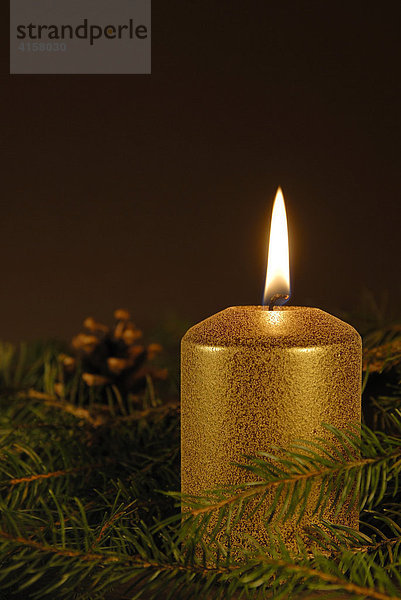 Eine brennende Kerze mit Weihnachtsdekoration