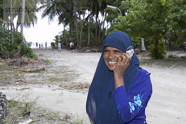 Frau mit Kopftuch und Handy  Malediven