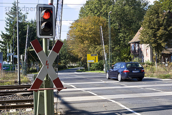 Fahrzeug fährt über noch geöffnete Bahnschranke mit Andreaskreuz und roter Ampel Hessen  Deutschland