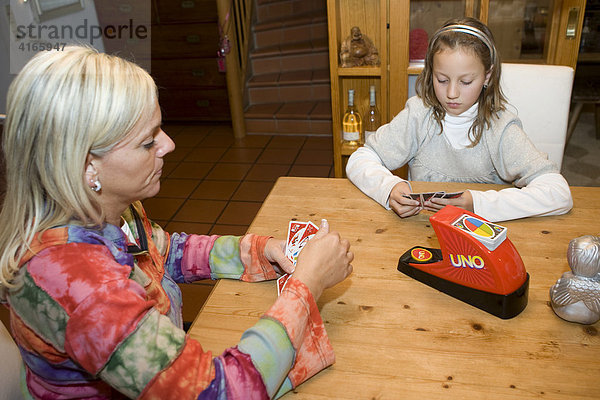 Mutter spielt mit 10jährigem Kind Karten