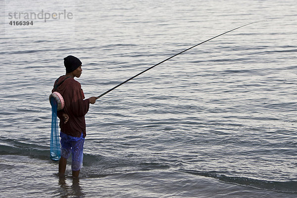 Fischer angelt bei Regen am Ufer  Insel Lombok  Kleine Sunda-Inseln  Indonesien