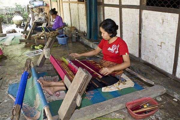 Frau webt in traditioneller Weise Stoffe an einem alten Webstuhl  Tete Batu  Insel Lombok  Kleine-Sunda-Inseln  Indonesien
