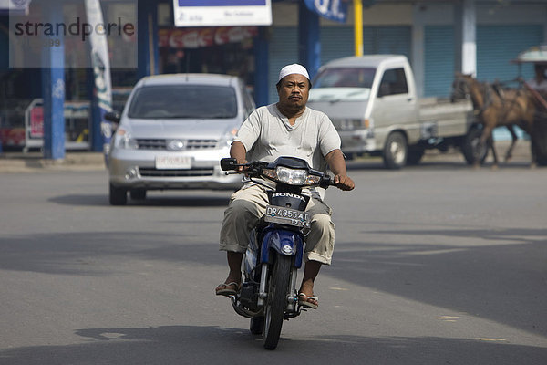 Moslem fährt auf einem Moped durch die Straßen  Hauptstadt Mataram  Insel Lombok  Kleine-Sunda-Inseln  Indonesien