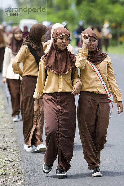 Schüler (Muslima) gehen nach der Schule in der traditionellen Schulkleidung auf einer Straße bei Mataram  Insel Lombok  Kleine-Sunda-Inseln  Indonesien