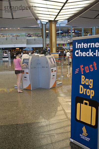 Junge Frau am Internet Check-In in der Abflughalle am Changi Airport  Flughafen  Singapur  Südostasien  Asia