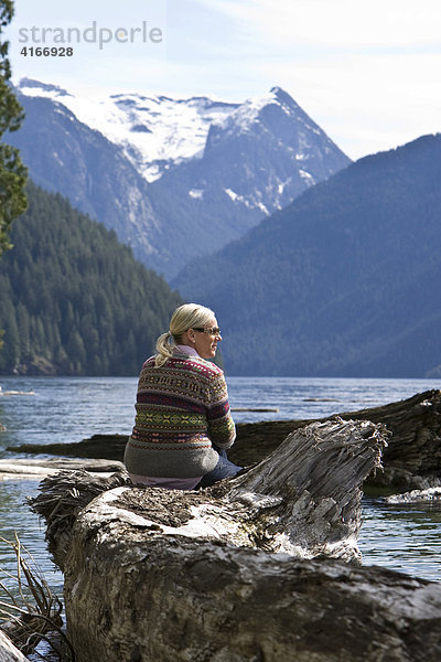 Frau sitzt am Ufer des Pitt Lake  British Columbia  Kanada  Nordamerika