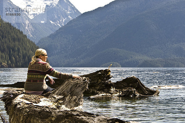 Frau sitzt am Ufer des Pitt Lake  British Columbia  Kanada  Nordamerika