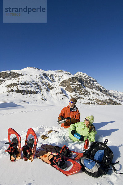 Junges Paar macht Rast beim Schneeschuhlaufen  Bieler Höhe  Galtür  Tirol  Österreich