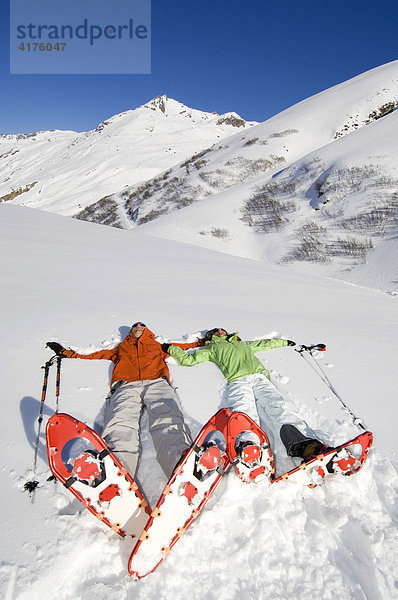 Im Schnee liegendes Paar während Schneeschuhtour  Bielerhöhe  Galtür  Tirol  Österreich