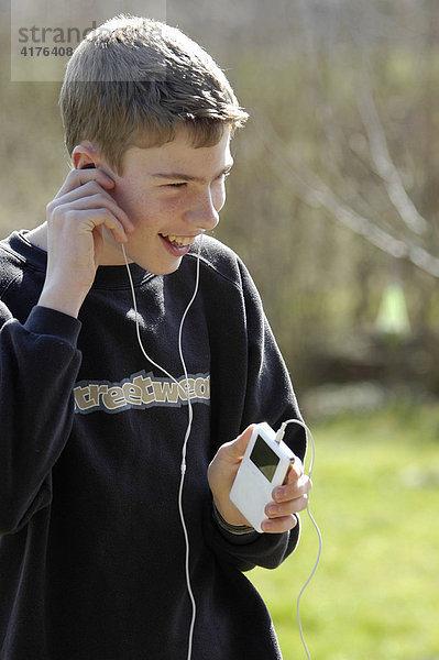 Jugendlicher hört musik mit einem mp3 player ( apple ipod )