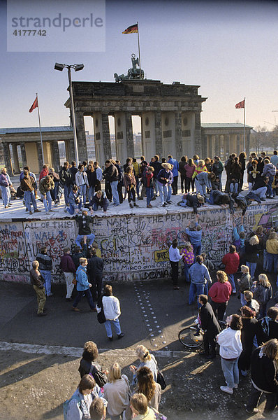 Fall der Berliner Mauer: Menschen aus Ost- und West-Berlin sind auf die Mauer am Brandenburger Tor geklettert. Berlin  Deutschland